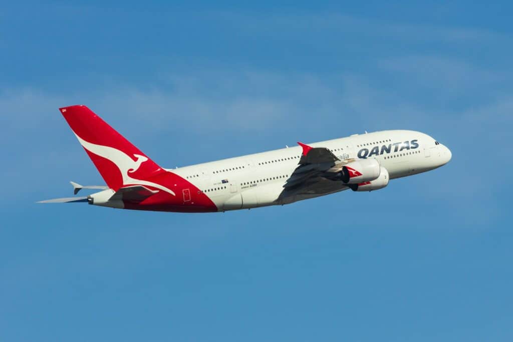 Qantas airplane flying in the blue sky.
