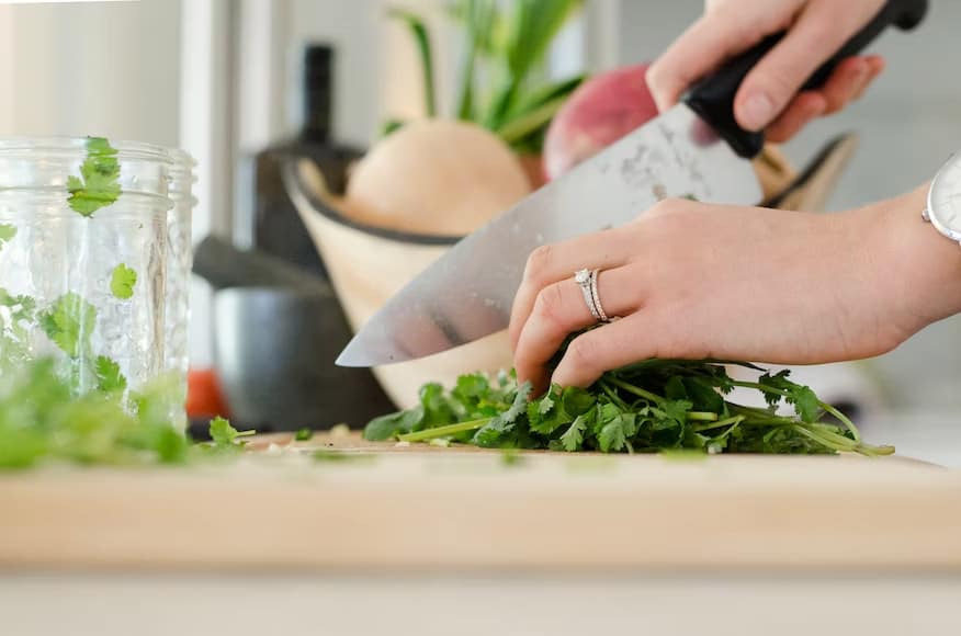 Chopping vegetables and edible plants for a healthy meal.