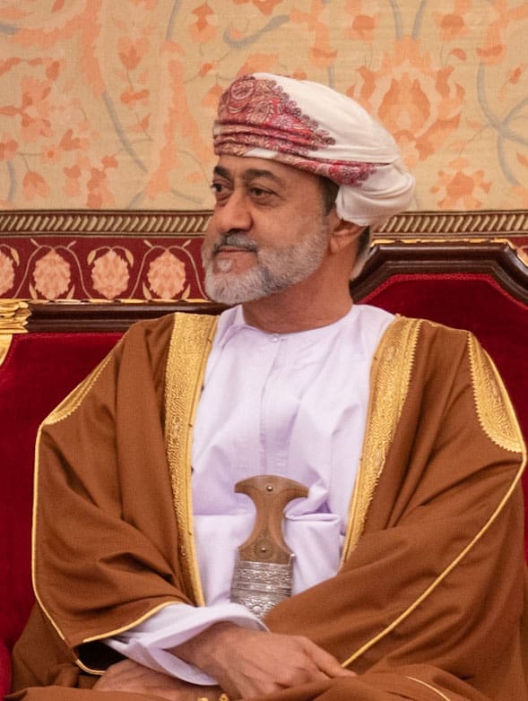 Sultan Haitham bin Tariq Al Said in his robes, sitting on a chair.