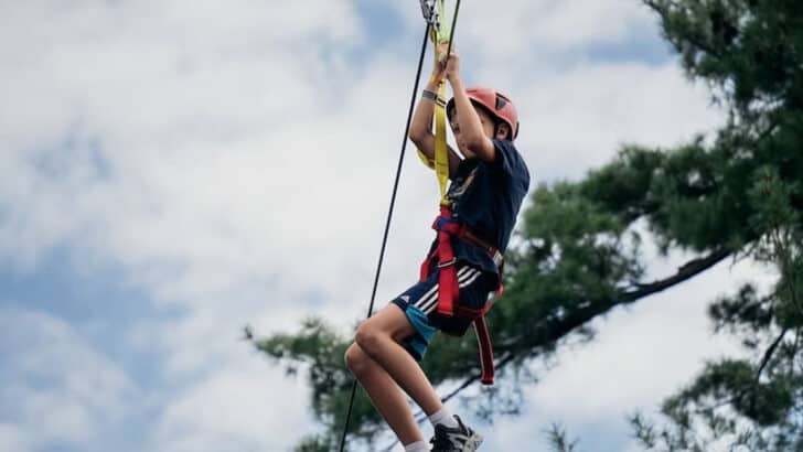 A kid swinging on a zip line.