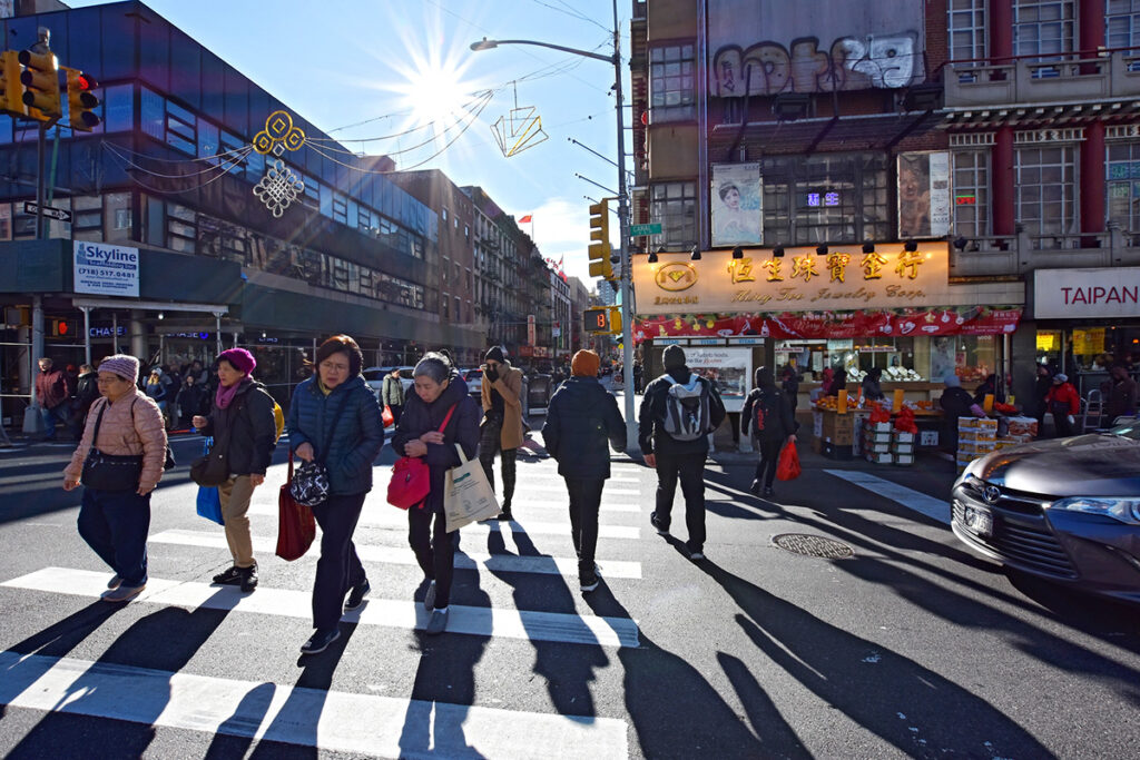 Pedestrians crossing Canal Street between Little Italy and Chinatown