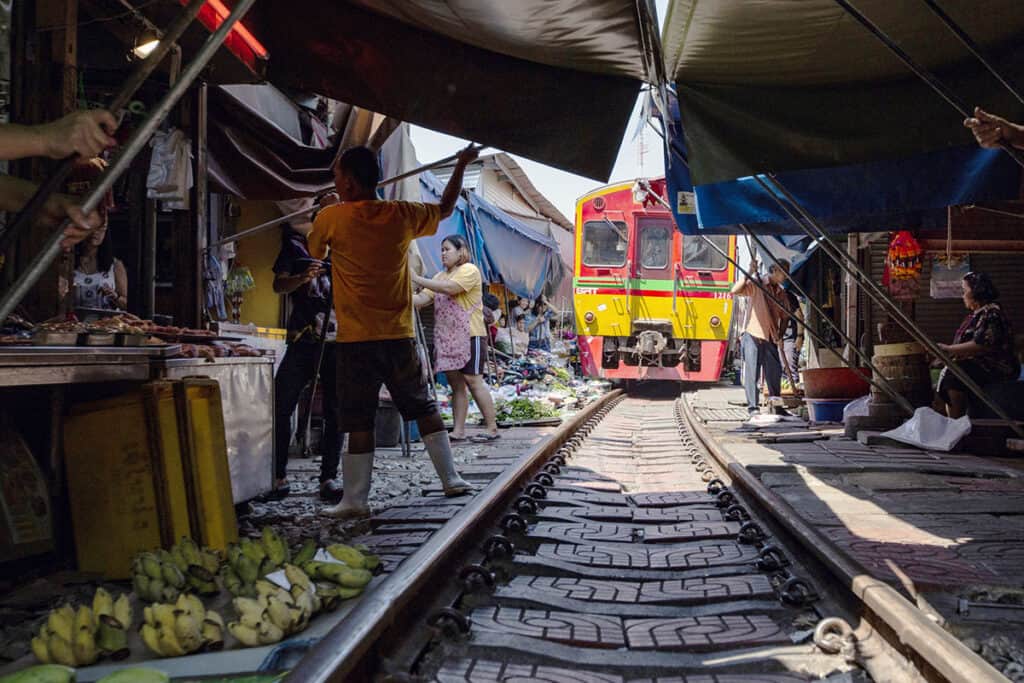 Putting awnings down at Maeklong Railway Market