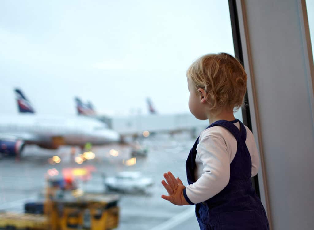 Baby looking out airport window