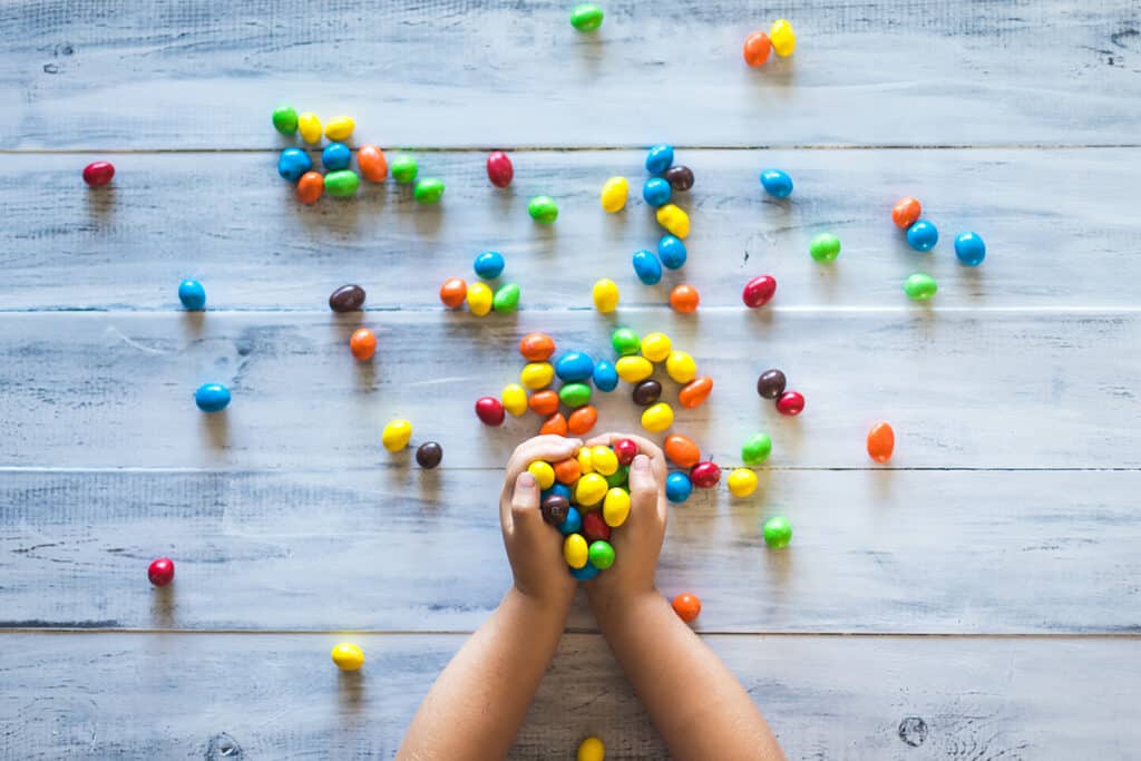 Child with hands full of candy