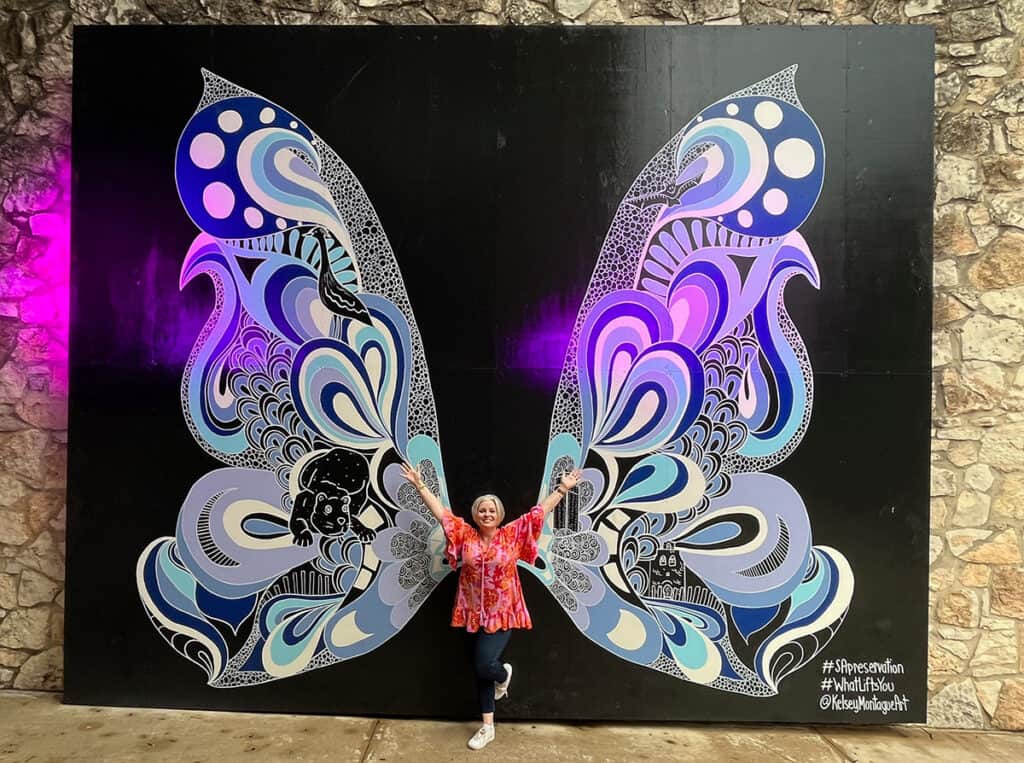 Megan in San Antonio in front of butterfly mural