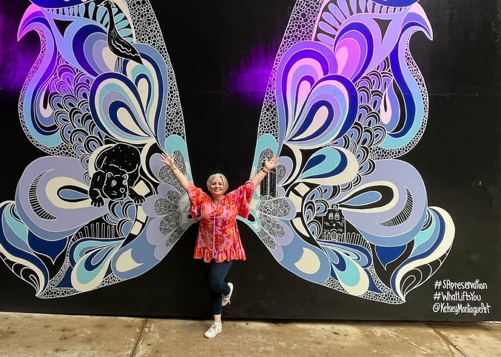 Megan in front of butterfly wings