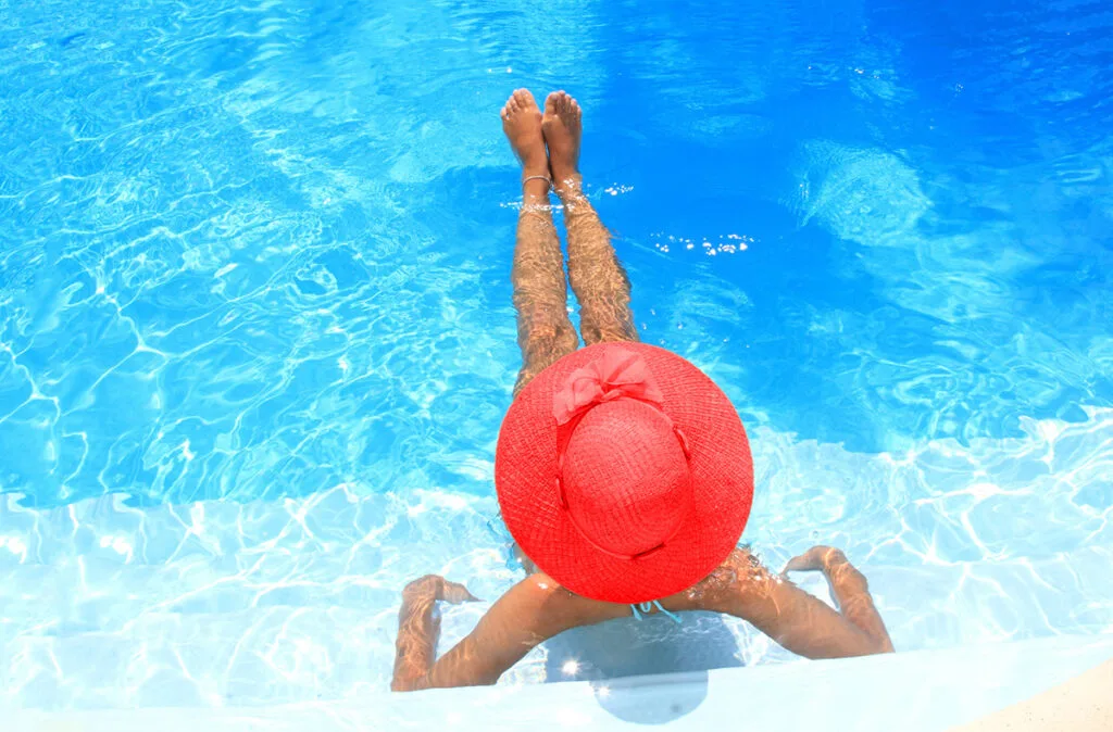 Woman in pool in red hat