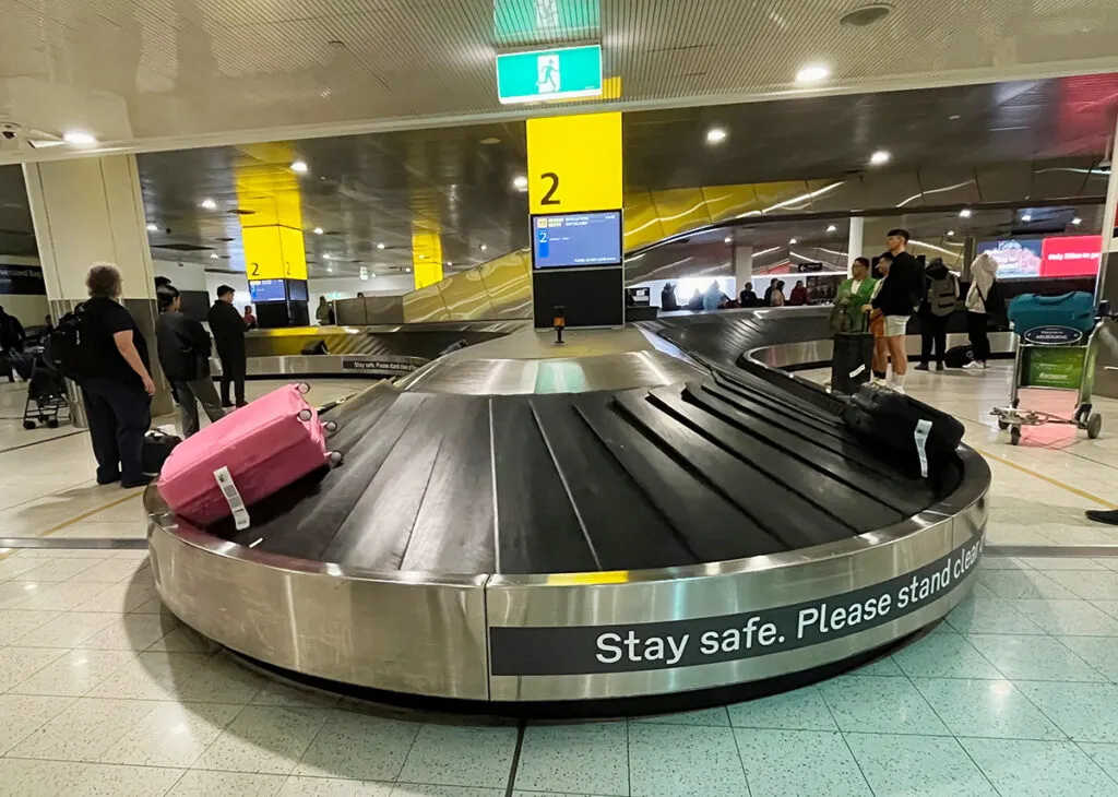 Bright pink suitcase on baggage carousel
