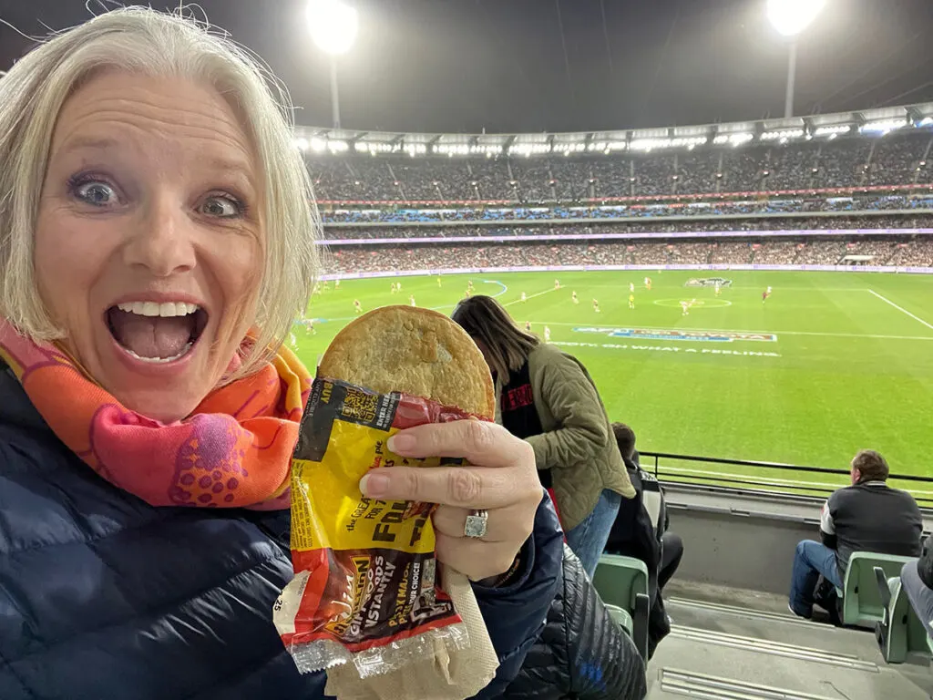Megan eating pie at AFL game