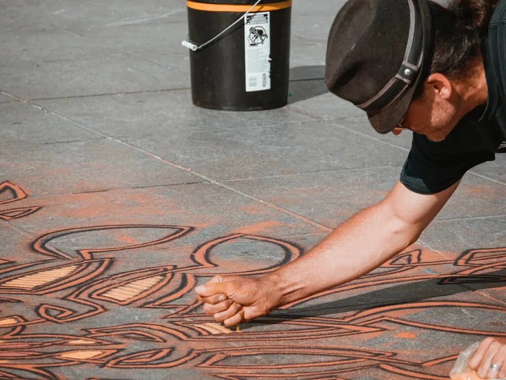 sand artist working on pavement