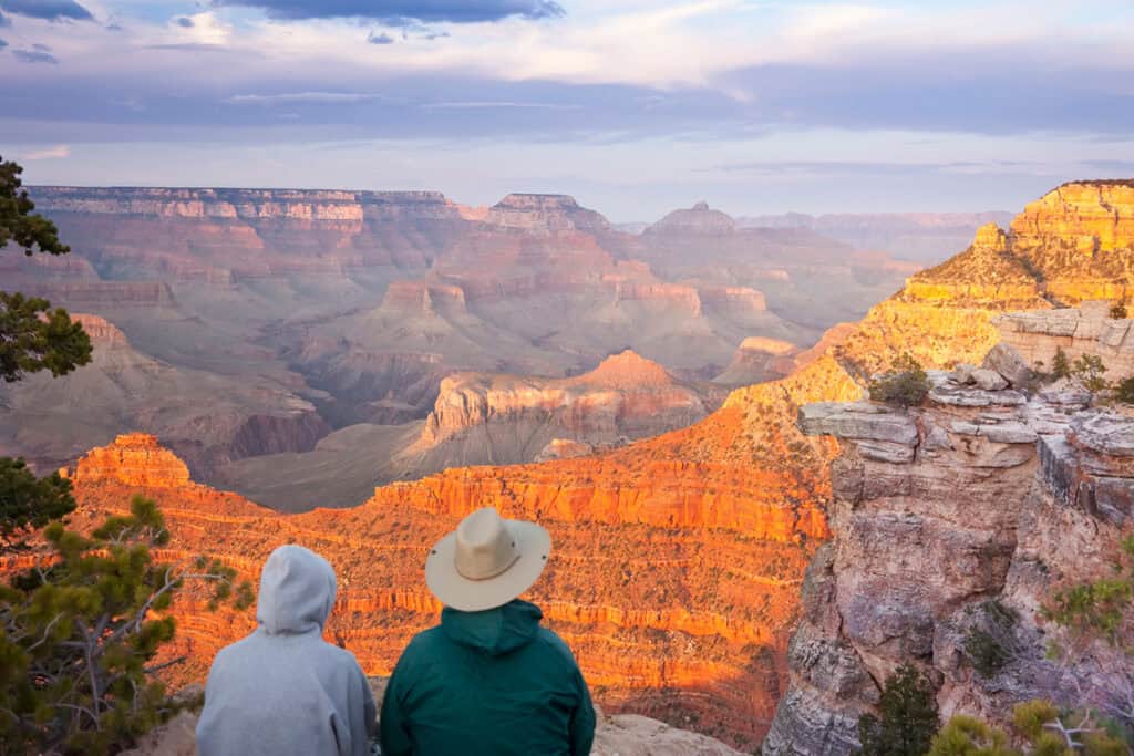 Couple sitting at South Rim looking at the Grand Canyon