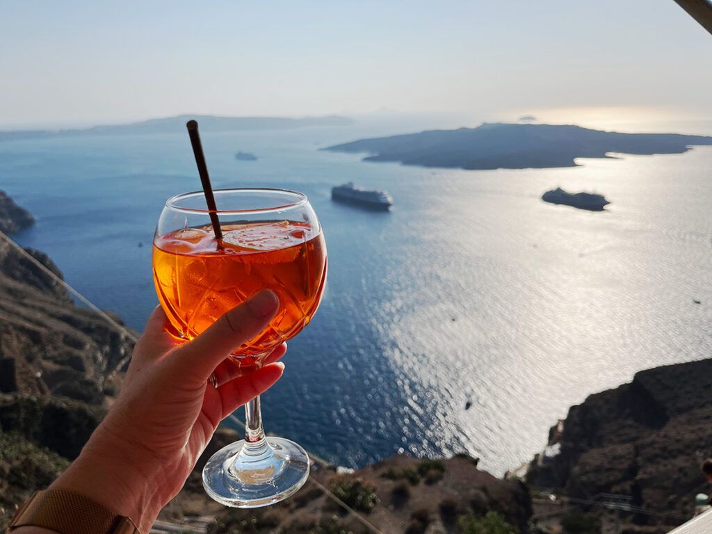 My Aperol Spritz in a bar in Fira, Santorini with our ship below