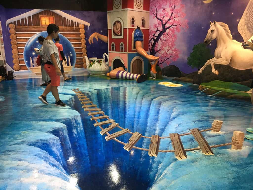 Boy walking on painted floor mural of waterfall