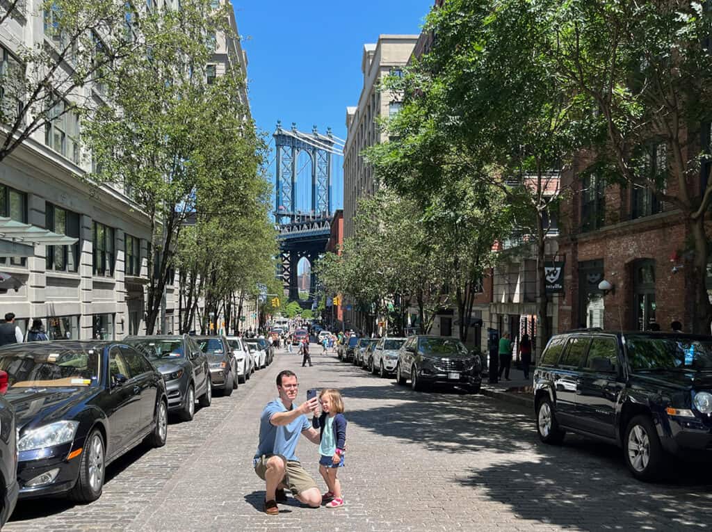 Father and daughter getting a selfie at the Brooklyn Bridge