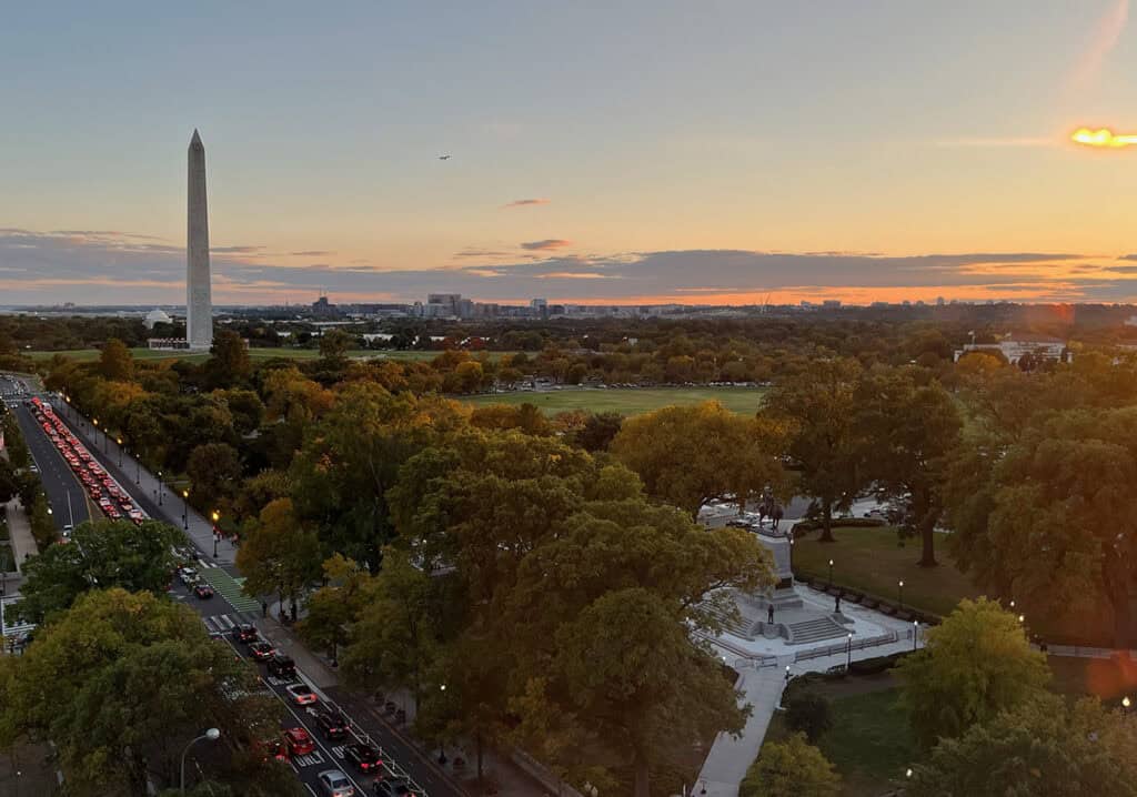 Washington Monument at sunset with plane in view