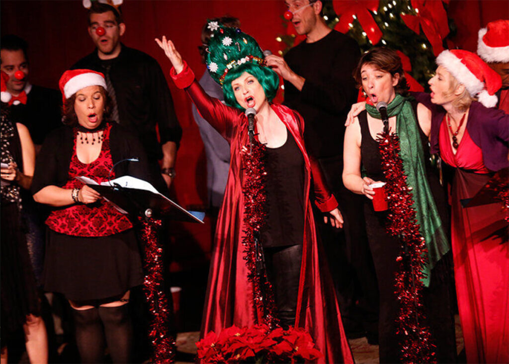Choralsters dressed in Christmas attire singing on stage at the Orpheum Theatre