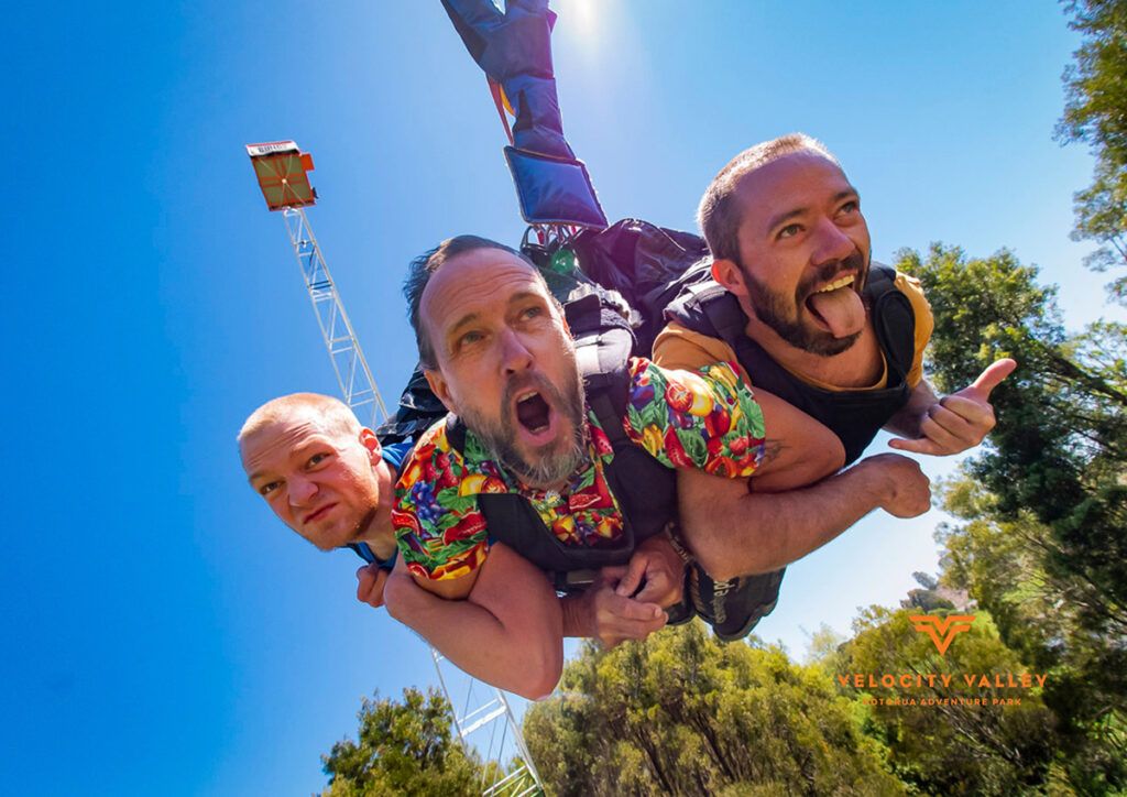 Three men screaming their heads off on the swoop swing