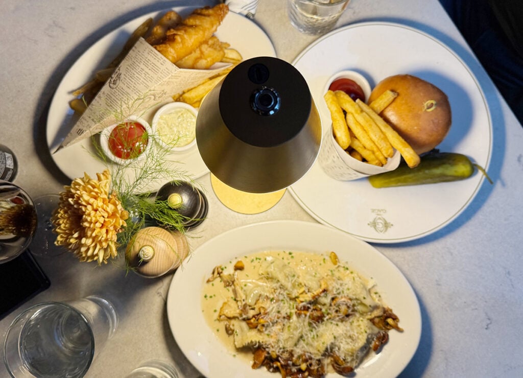 Three plates of food at the Gage, fish and chips, mushroom pasta and a burger