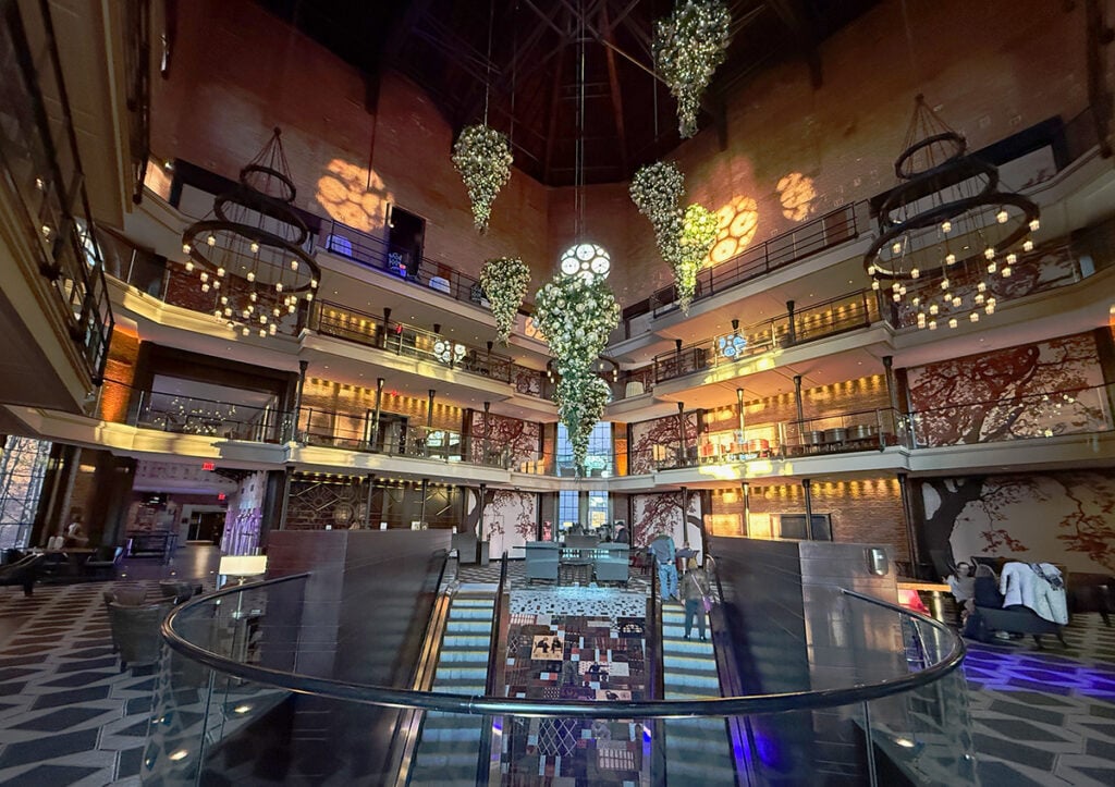 The Liberty Hotel escalators bring you up in to the soaring atrium reception and bar area where chandeliers and decorations hang from the ceiling
