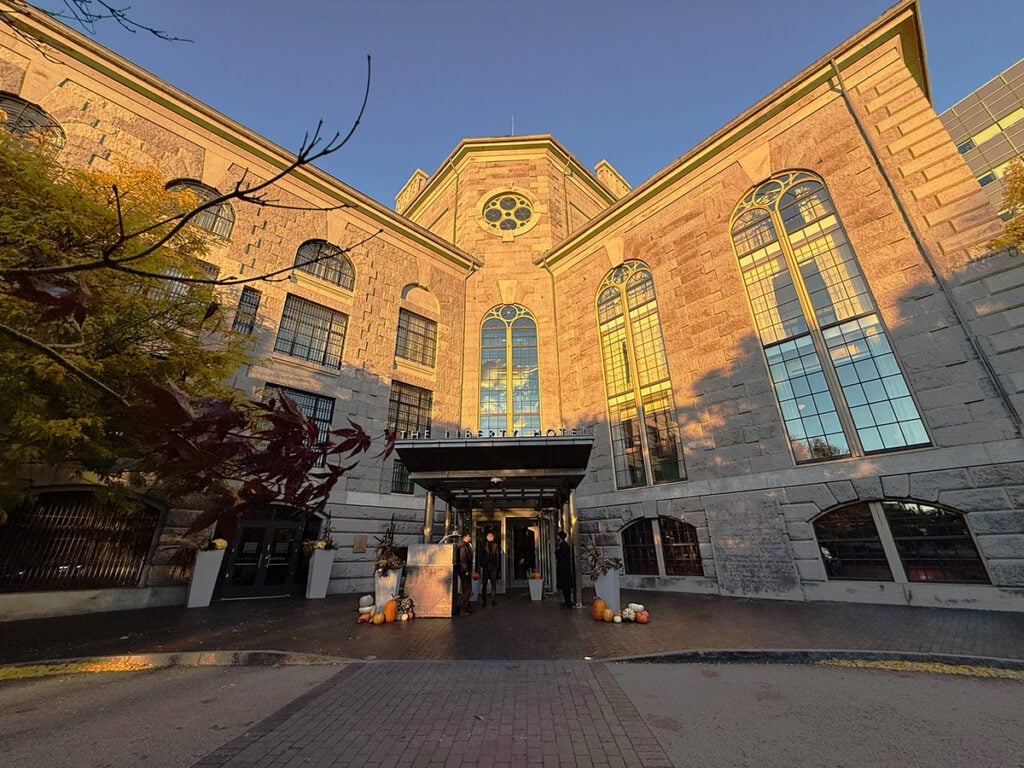 The Liberty Hotel Boston entrance with the sun shining on its historic bricks