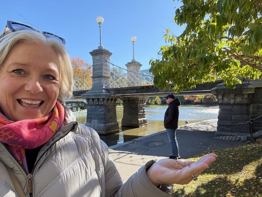 Megan with her husband looking like he's standing on her hand in Boston Public garden