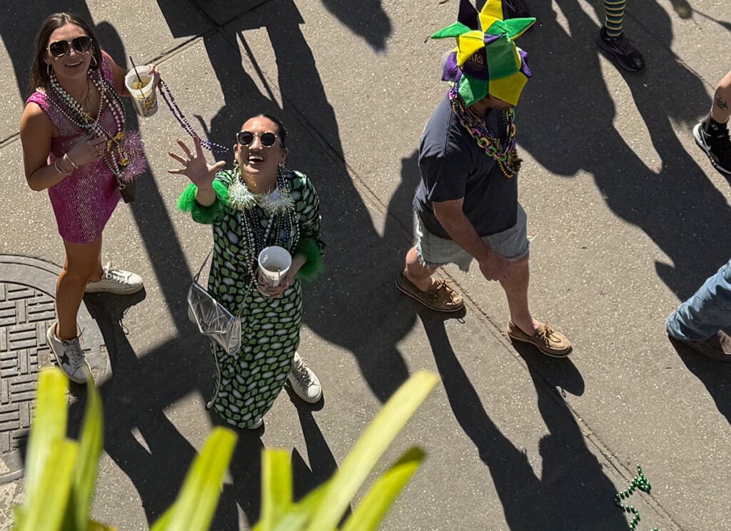 Lady catching beads from balcony
