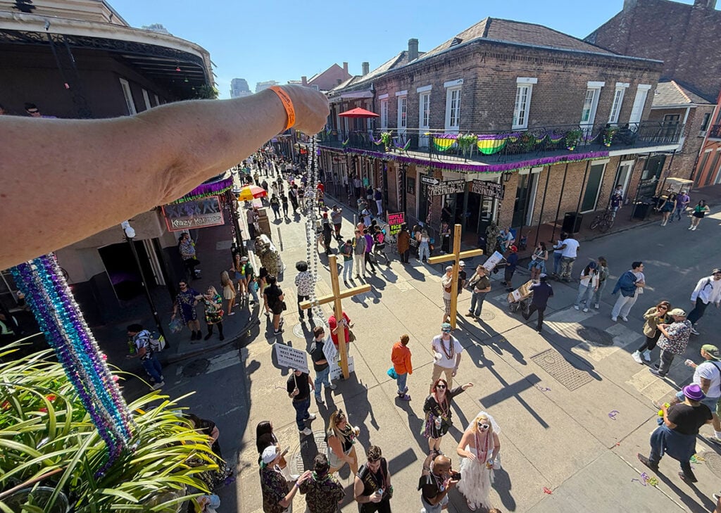 Dangling beads from balcony on Bourbon Street to throw