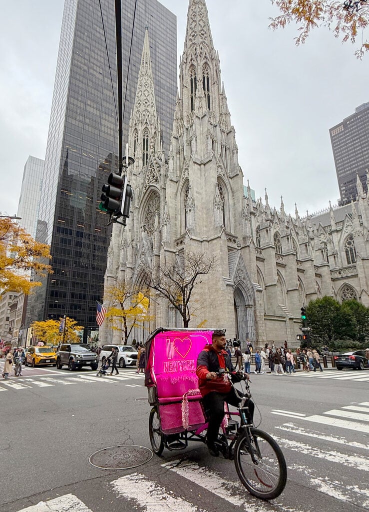 Pedicab rider with pink cab looking for a customer in New York