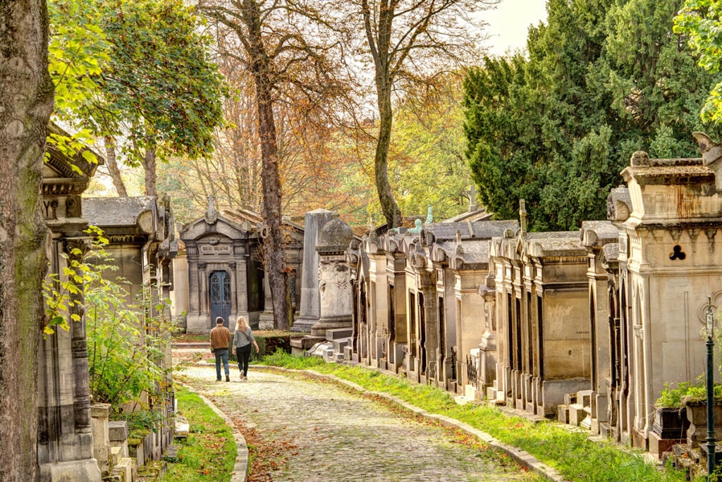 A couple strolling through Père Lachaise Cemetery