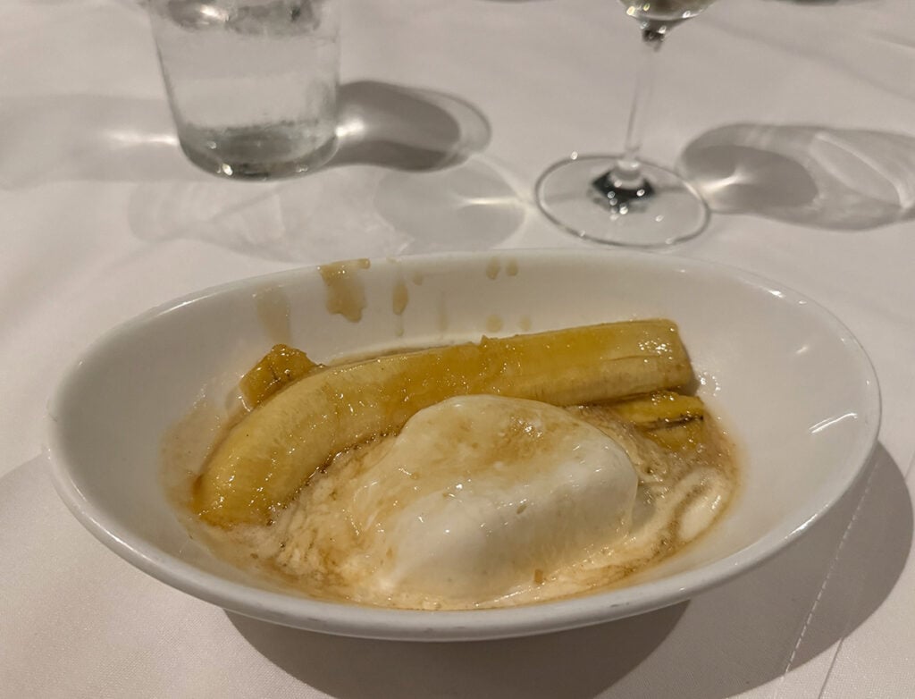 Bowl of ice cream with bananas and lashings of caramel sauce