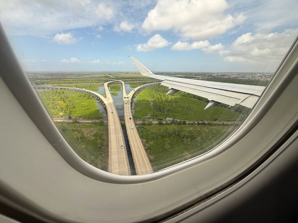 View out the plane window coming in to land over the highway and bayou