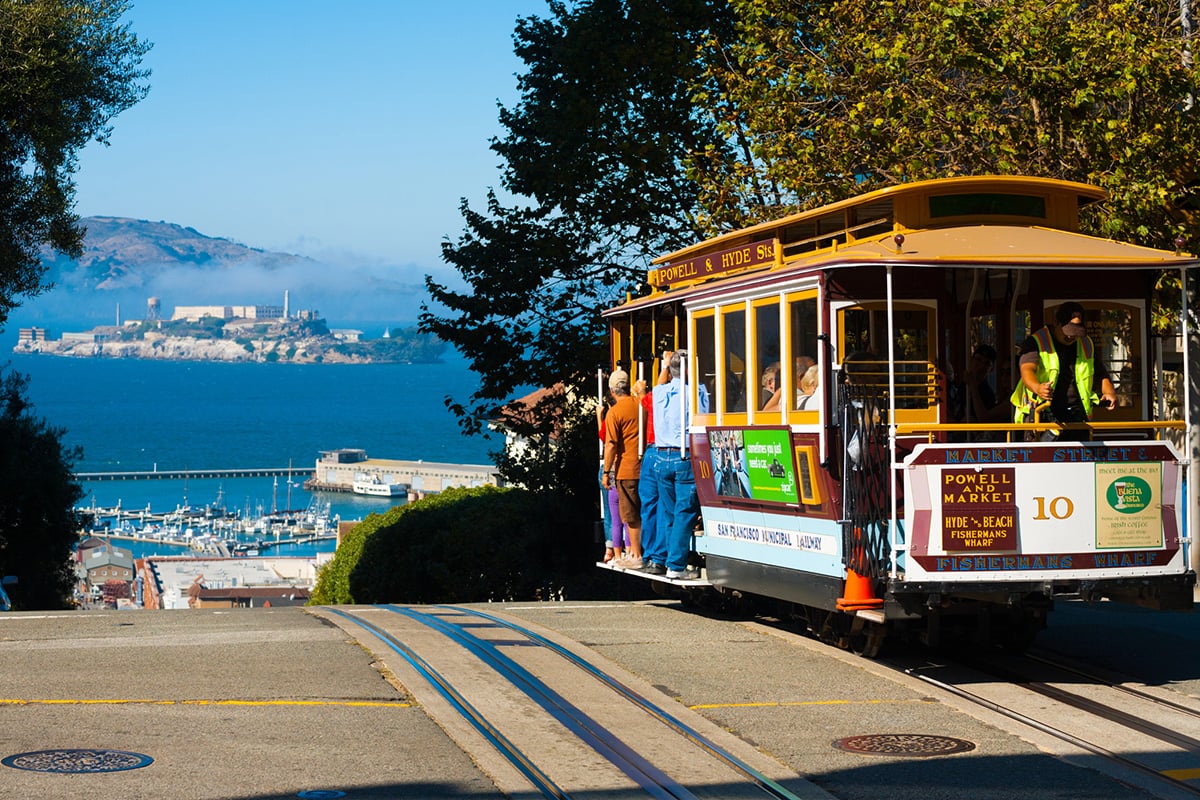 The Cable Car sits at the top of the hill with Alcatraz in the background