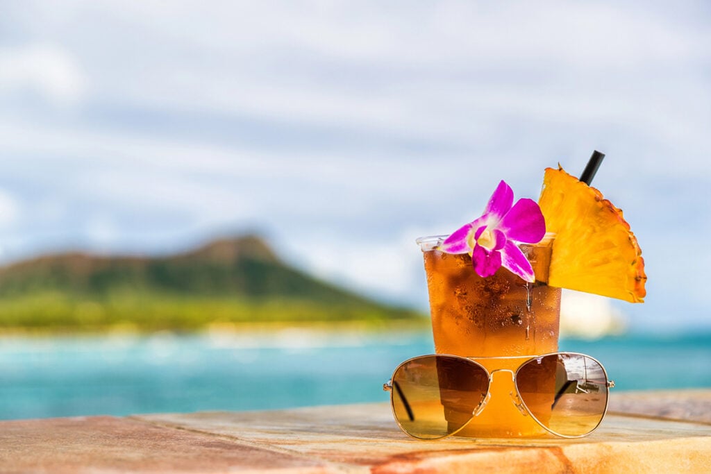 Mai tai with umbrella in the glass and Diamond Head behind