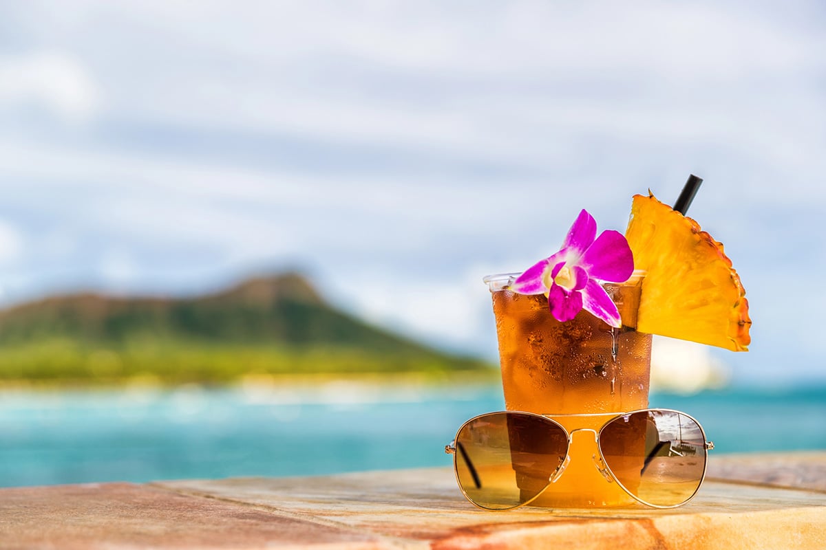 Mai tai with umbrella in the glass and Diamond Head behind