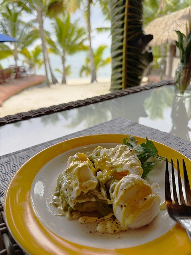 Eggs benedict at Tamanu Beach Resort with the beach behind