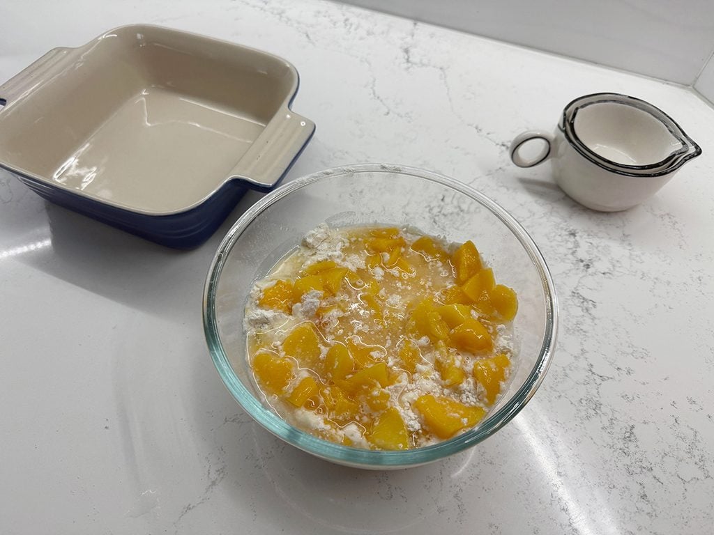 Mixing peaches into flour and sugar