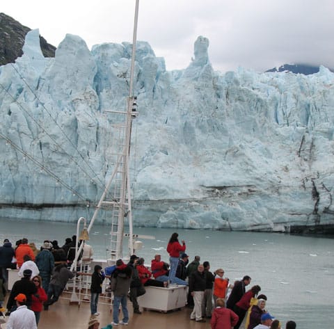 Tourists flocking on the bow of the ship watching the Margerie Glacier in the Glacier Bay National Park.