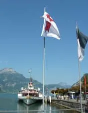 A white paddle steamer docked in Lake Lucerne.